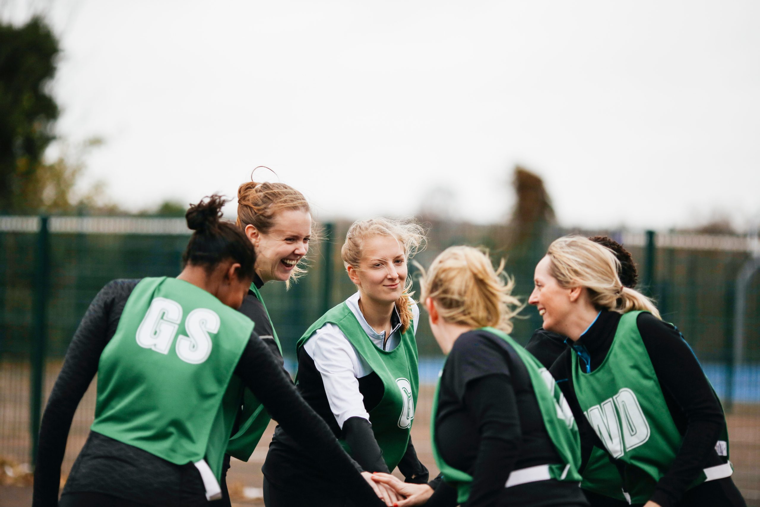 Female netball team shaking hands on netball court